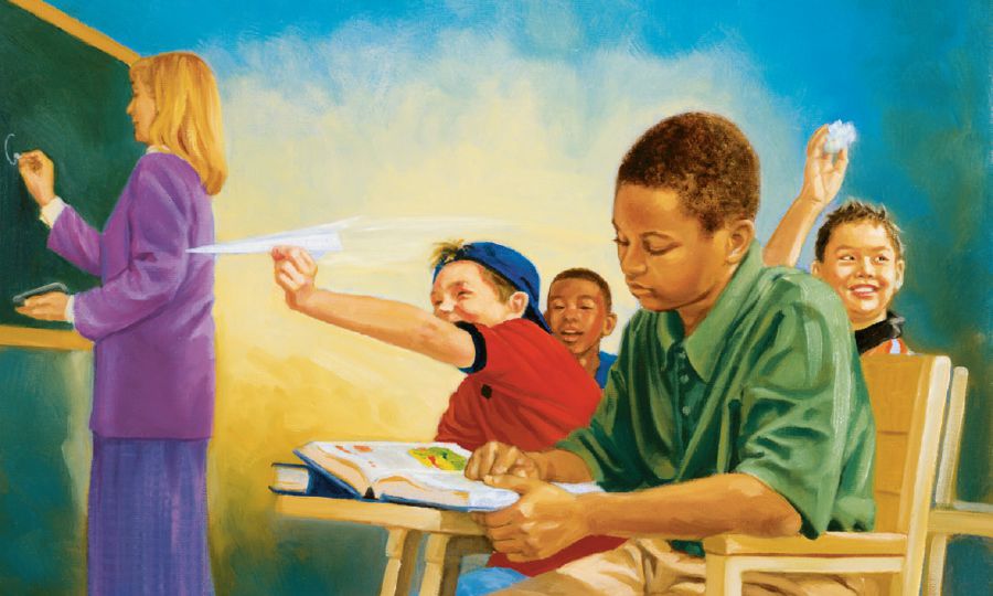 At school, a boy studies while his classmates misbehave