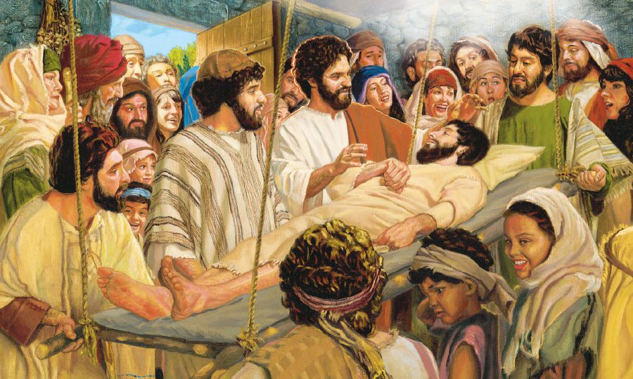 A paralyzed man on a cot is lowered through the roof to Jesus