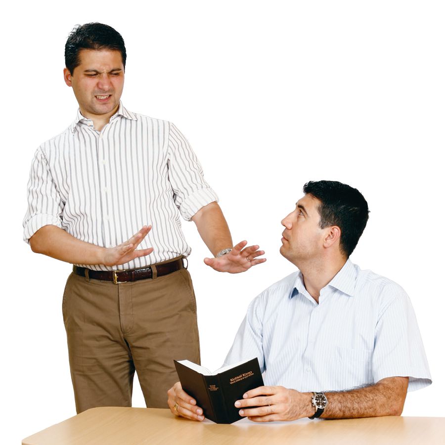 A man reads the Holy Scriptures and another man shuns him