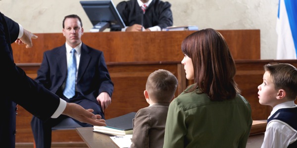 A man on trial in a courtroom with his family looking on