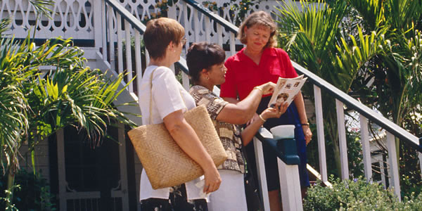 Two Christians sharing the good news with a woman at her home
