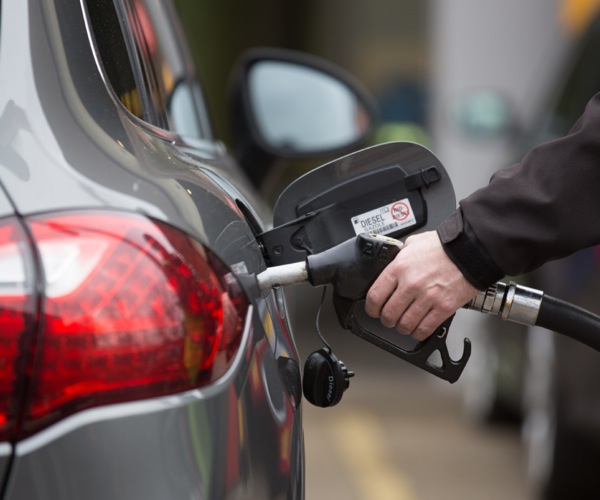 A man pumping diesel fuel into the tank of a car