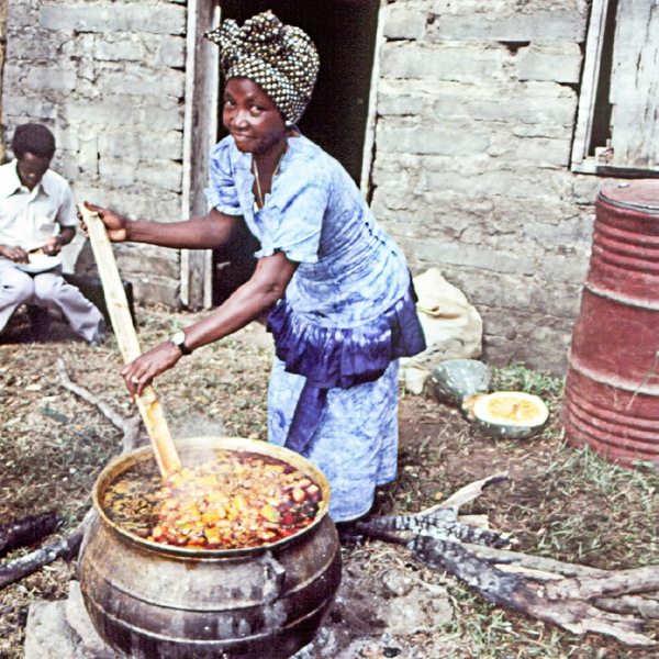 A sister stirs a pot of food in Sierra Leone
