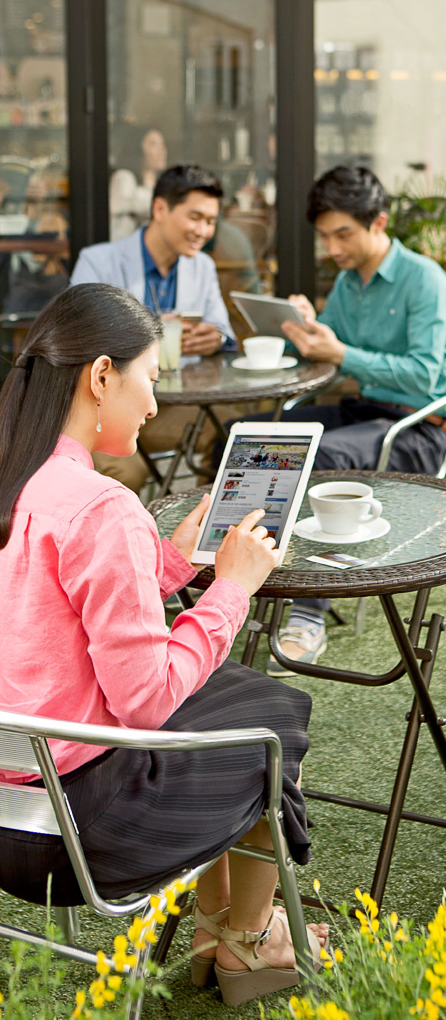 A woman looks at the jw.org website while sitting at an outdoor cafe
