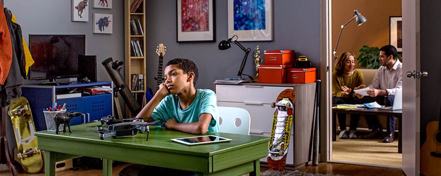 A boy is unhappy in a room filled with material things
