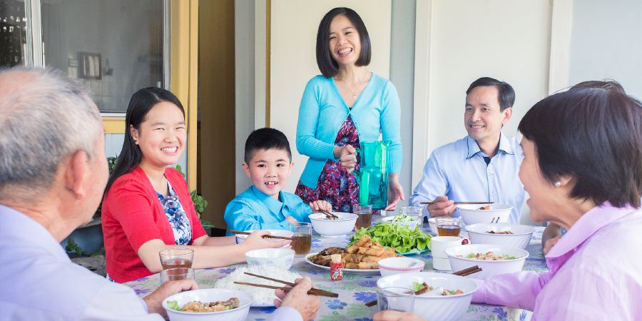A family extends hospitality to a couple by sharing a meal with them