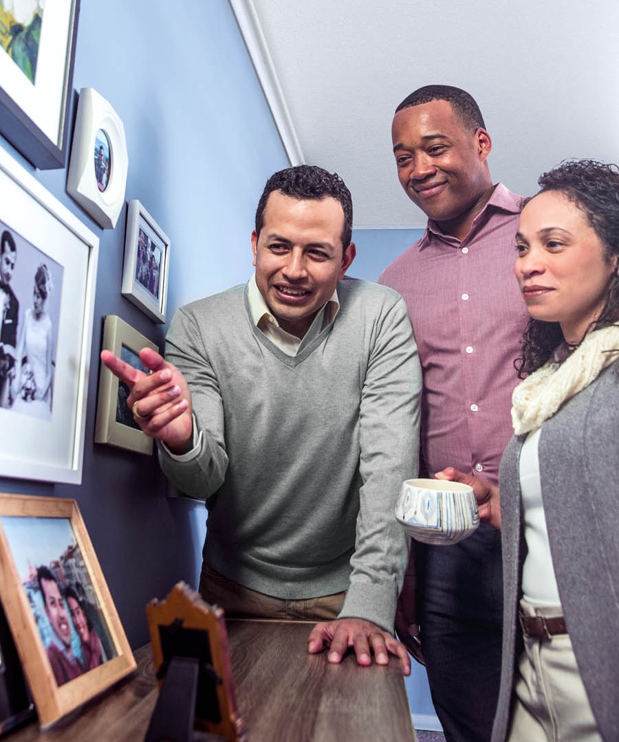 A man shows friends pictures of his deceased wife