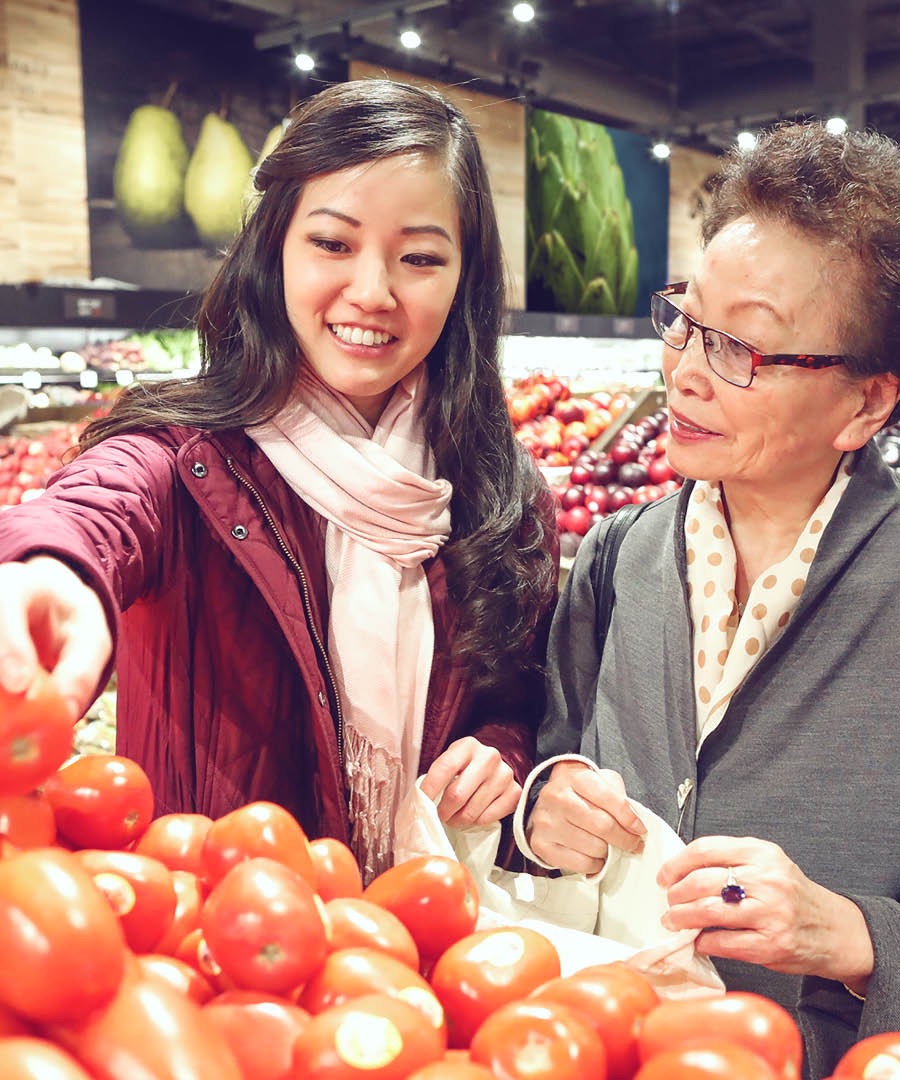 A young woman helps an older woman with her grocery shopping