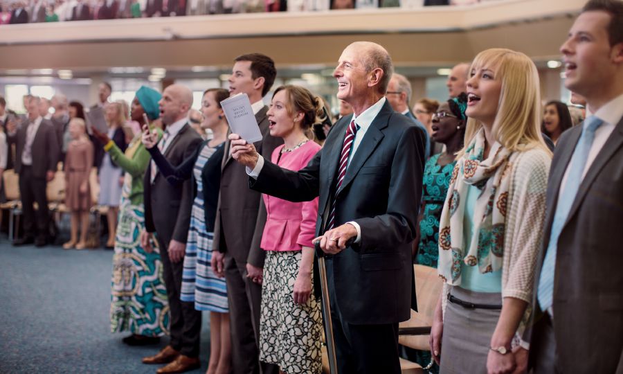 An elderly brother singing at a circuit assembly.