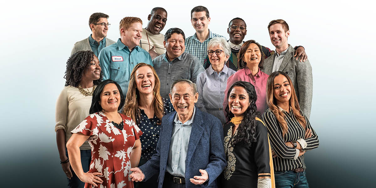 A group of people of different ages and from different racial backgrounds smiling.