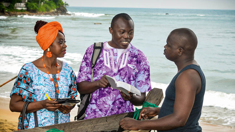 Judith and Sam-Castel preaching to a man on a beach.