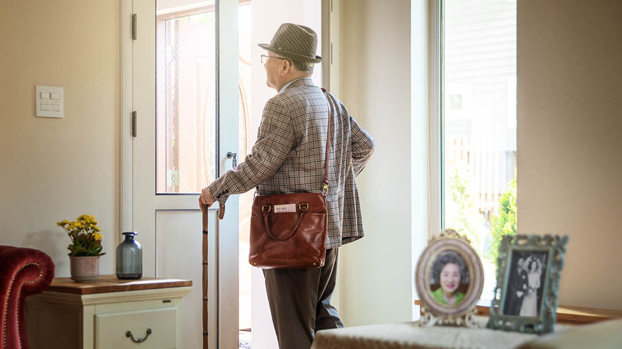 A widowed elderly brother leaving his home to go in field service. Pictures of his wife and their wedding day stand on a side table.