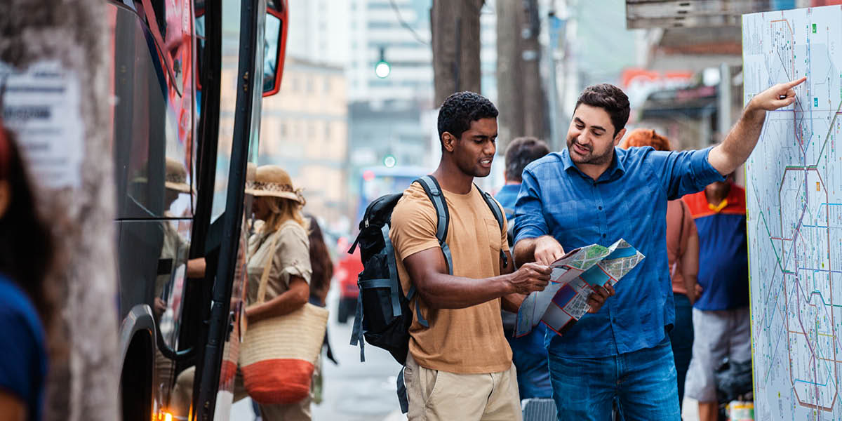 A man using a map to give directions to another man.