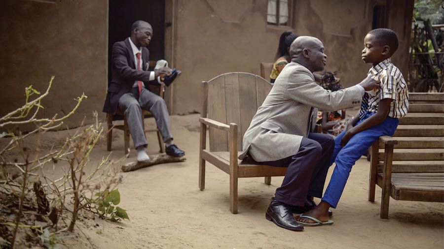 A scene from the video ‘Love Never Fails Despite . . . Poverty—Congo.’ Brothers put on dress clothes to attend a convention.