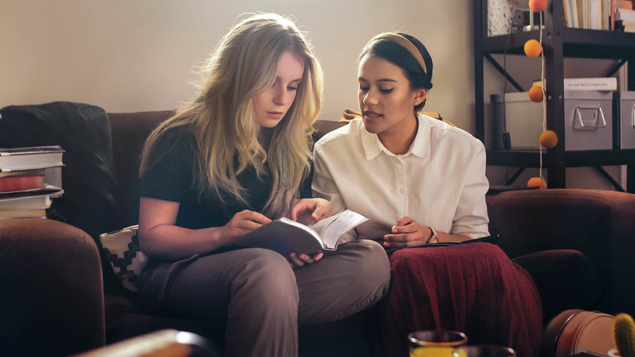 A scene from the video “Help Your Bible Students to Feed Themselves Spiritually.” Neeta helps Jade to find the answer in a scripture.