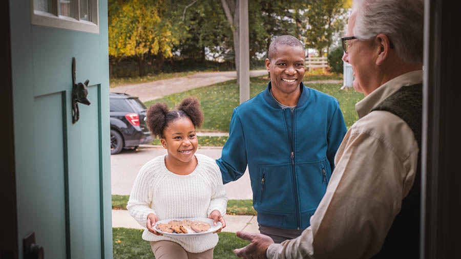 A brother and his young daughter bringing cookies to an elderly brother at his home.