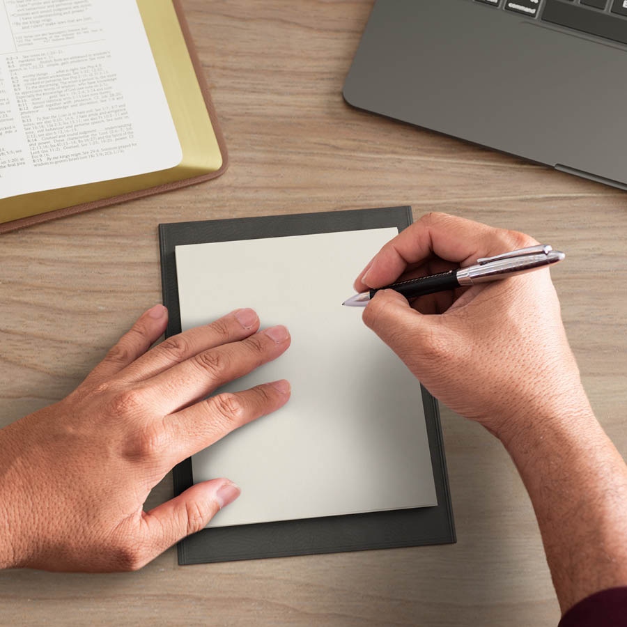 The man writing on the notepad.