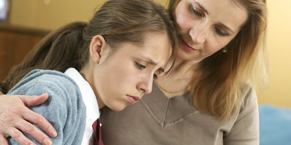 A mother comforting her teenage daughter