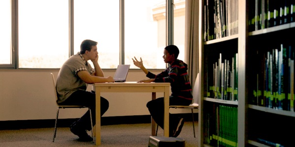 A young man explaining why he believes in God to a fellow student