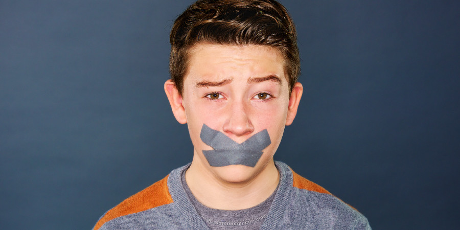 A teenage boy with tape over his mouth to prevent him from cursing