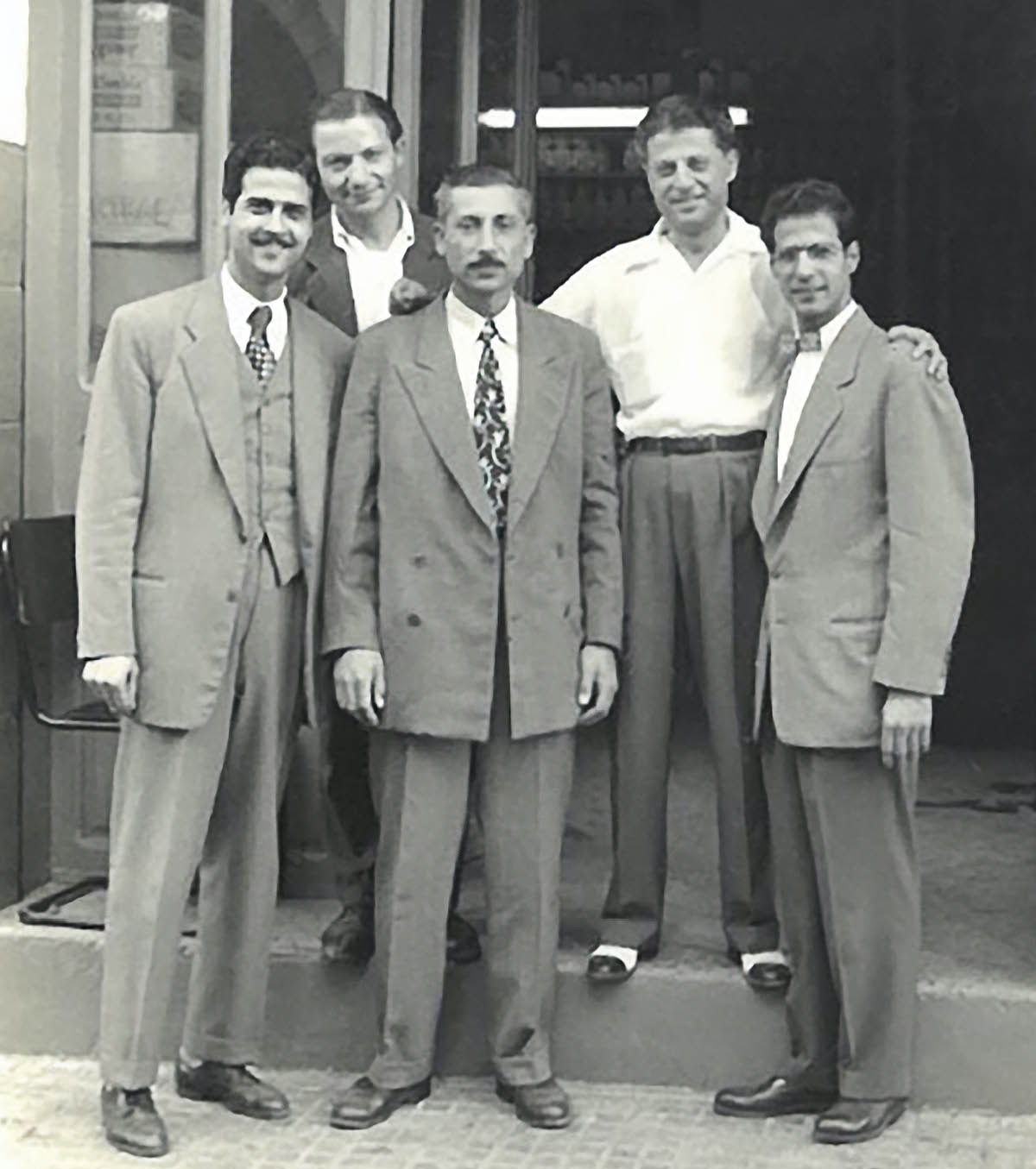 Milto and Philip Stavrou standing with Najib Salem and two other friends in front of Najib’s paint shop.