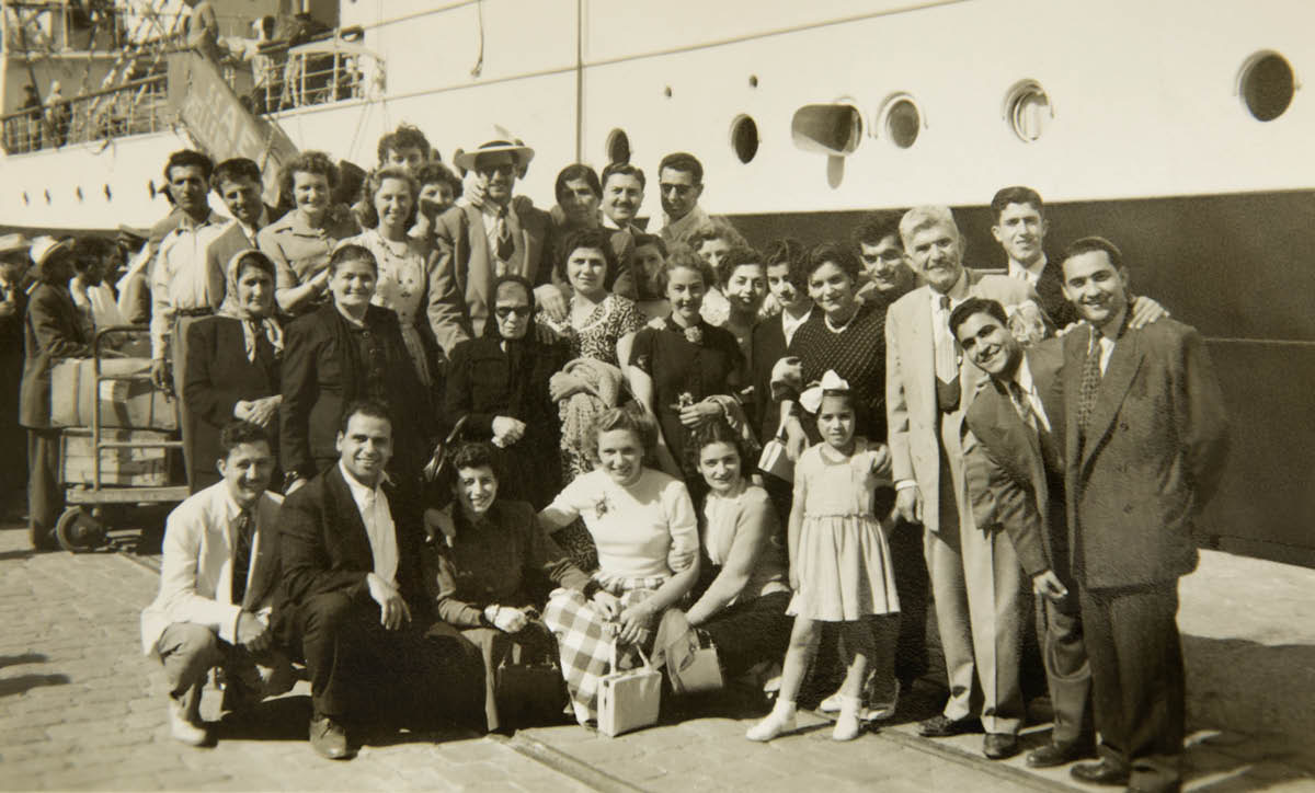 Milto with friends and relatives beside a large ship.