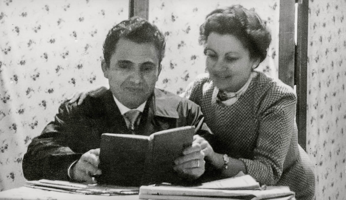 Antonio and Dorina reading together in front of the screen that separated their room.