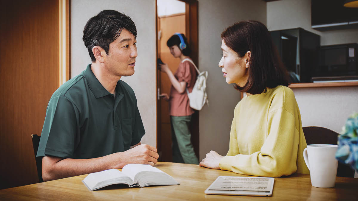 A father and mother using the Bible and discussing how best to counsel their teenage daughter.