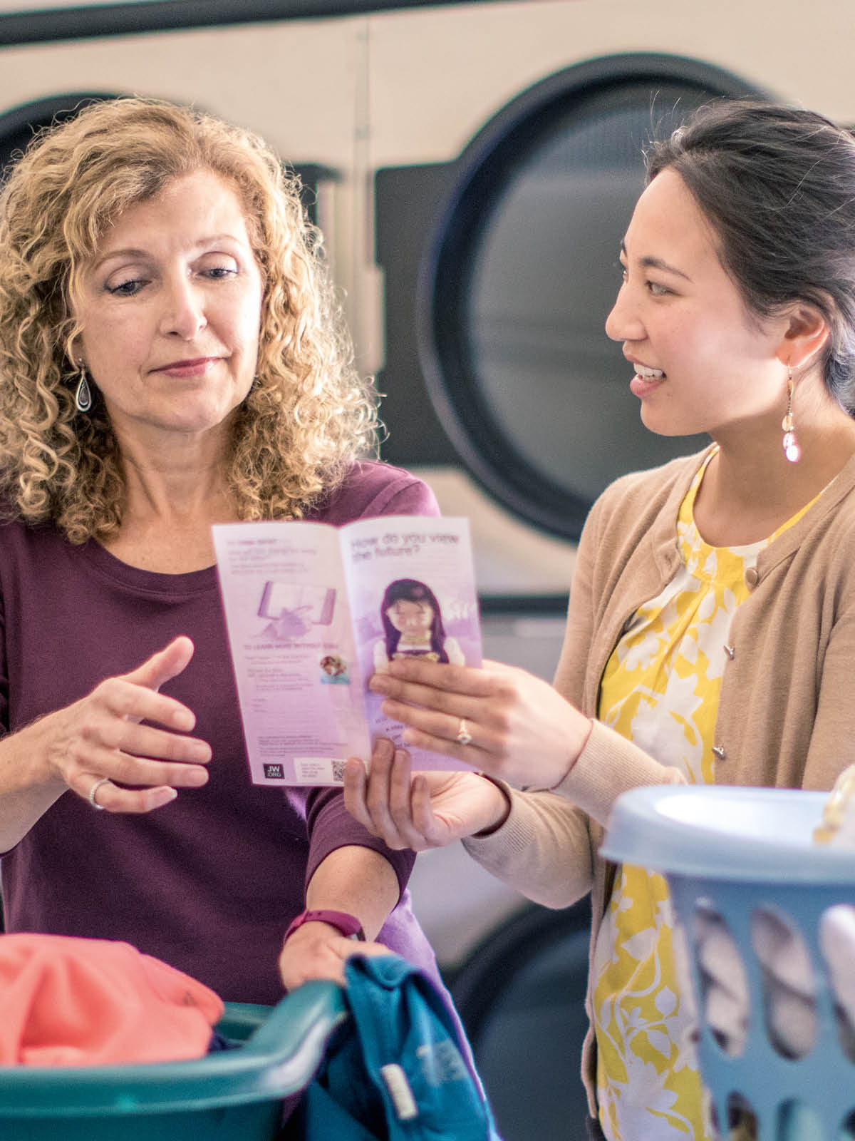 A sister giving a woman a tract at a laundromat.