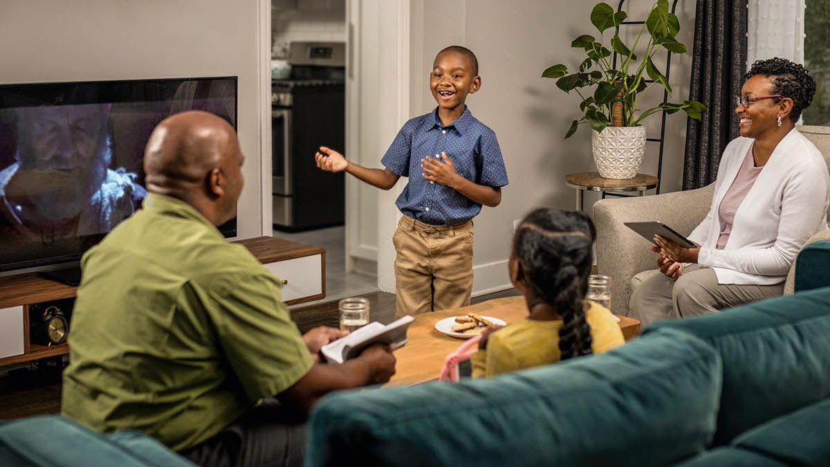 Parents and their two children during family worship. The young son talks about a point from the video “Daniel: A Lifetime of Faith.”