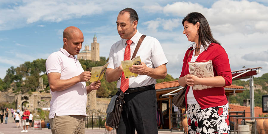 Luca and Giada offering literature to a man walking on the street.