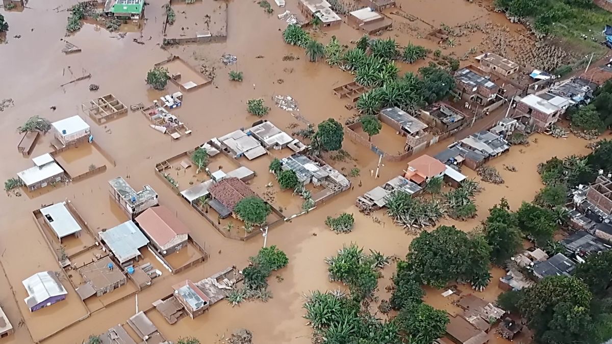 A scene from the video “Devastating Flooding in Brazil.” An aerial view of partially submerged houses and trees in a flooded neighborhood.