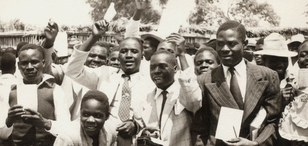 A group of brothers holding up a Cinyanja reading aid at a 1954 assembly in Chingola, Zambia.