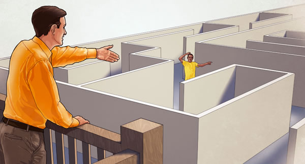 A man helps a teenage boy find his way out of a maze