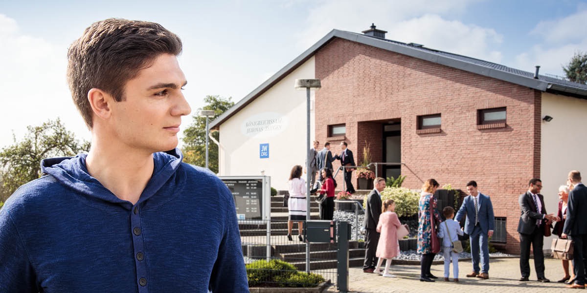 A young man observes people walking into a Kingdom Hall