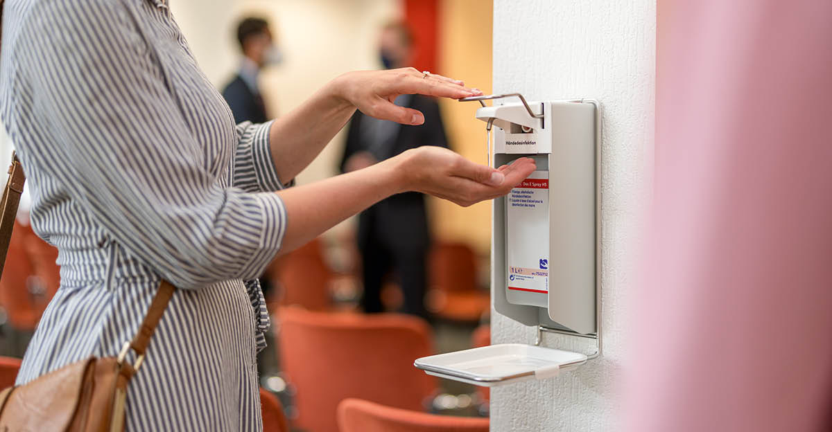 A sister using a hand-sanitizing station inside a Kingdom Hall.