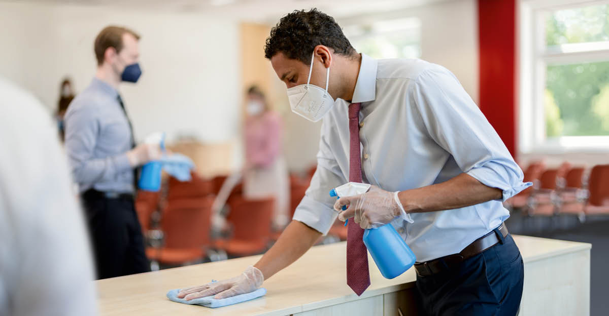 Two brothers wearing masks, disinfecting touch points at a Kingdom Hall.