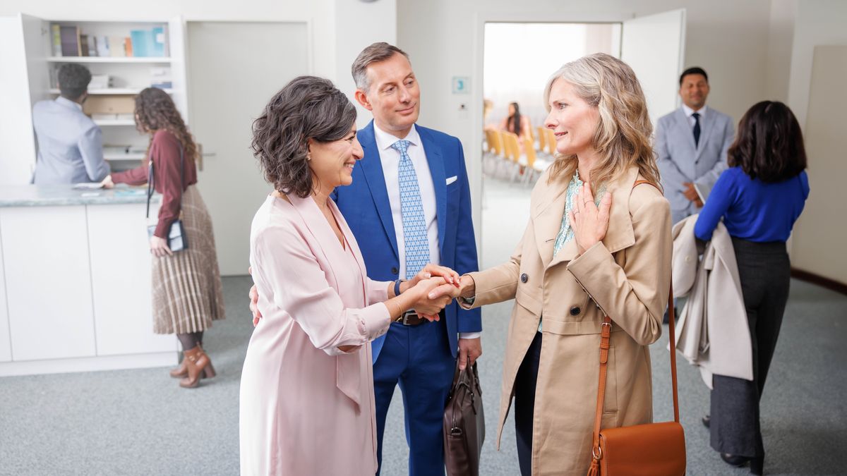 A Witness couple at the Kingdom Hall, warmly greeting a woman who was removed from the congregation.