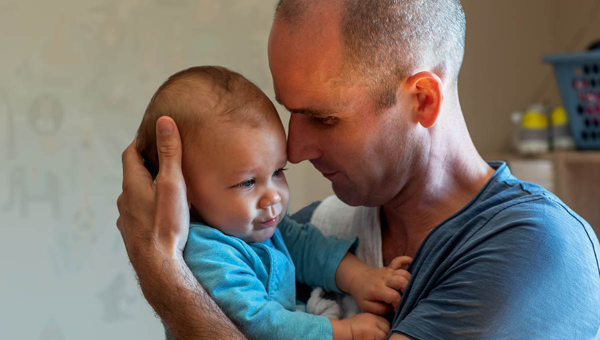 A new dad cradling his baby.
