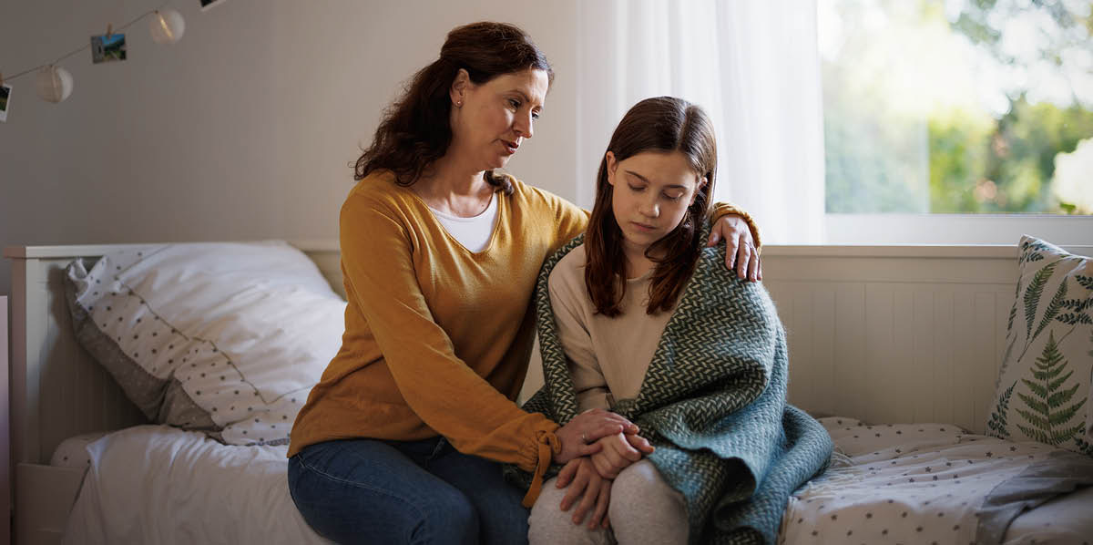 A mother consoling her despondent daughter.