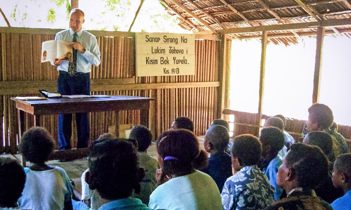Warren conducting a meeting with an isolated group in Papua New Guinea.