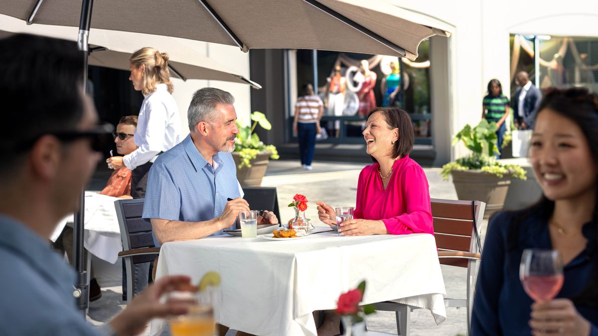 An older couple who are dating, chatting happily while enjoying a meal together at a restaurant.