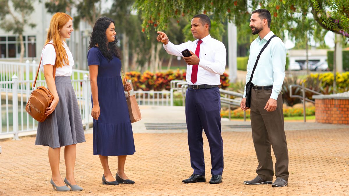 Two brothers and two sisters working together in the ministry. One of the brothers kindly directs the sisters to the area where they should preach.