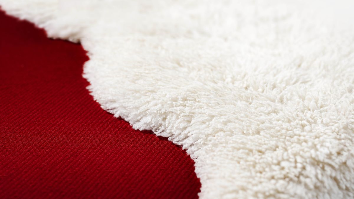 White wool next to a scarlet-colored carpet.