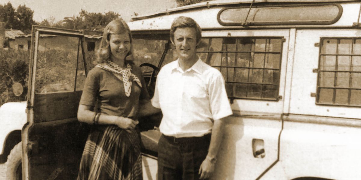 Mats and Ann-Catrin standing next to their SUV in a rural territory.