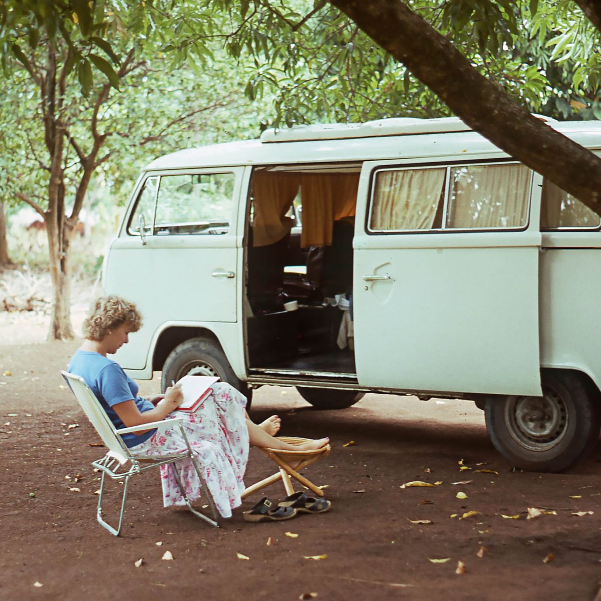 Ann-Catrin sitting on a folding chair outside their Volkswagen Kombi van.